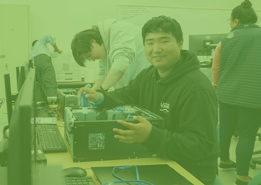 Student working on the interior parts of a computer.